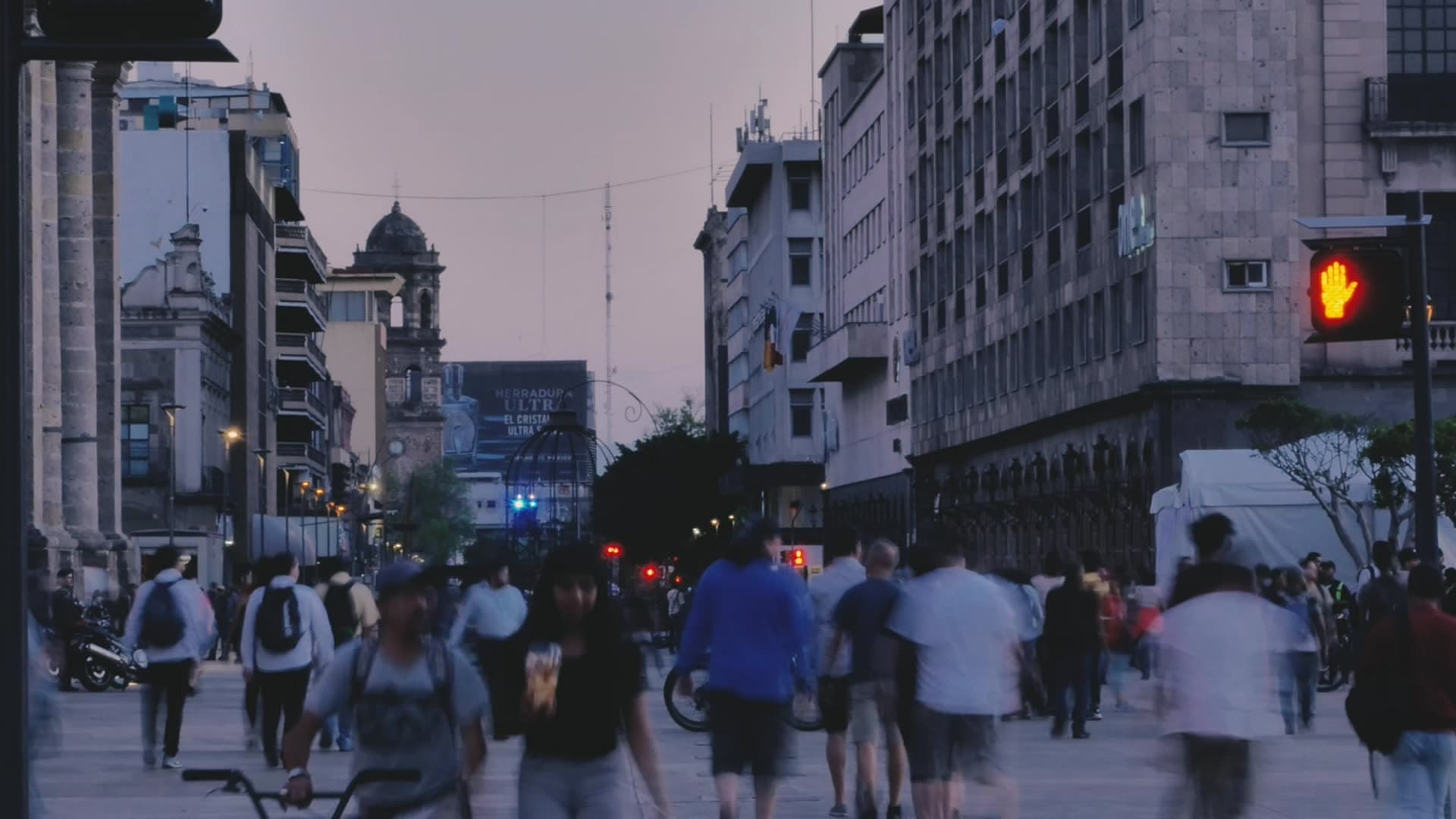 Pedestrians crossing a city street at dusk