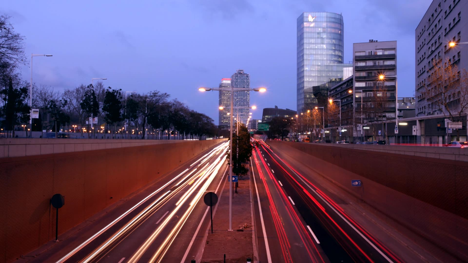 Light trails on an avenue at blue hour with office towers