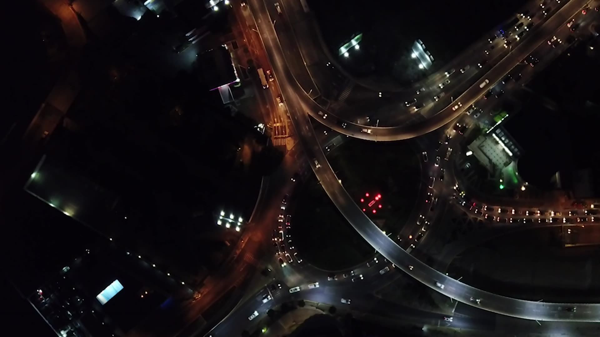 Aerial view of a lit highway interchange at night