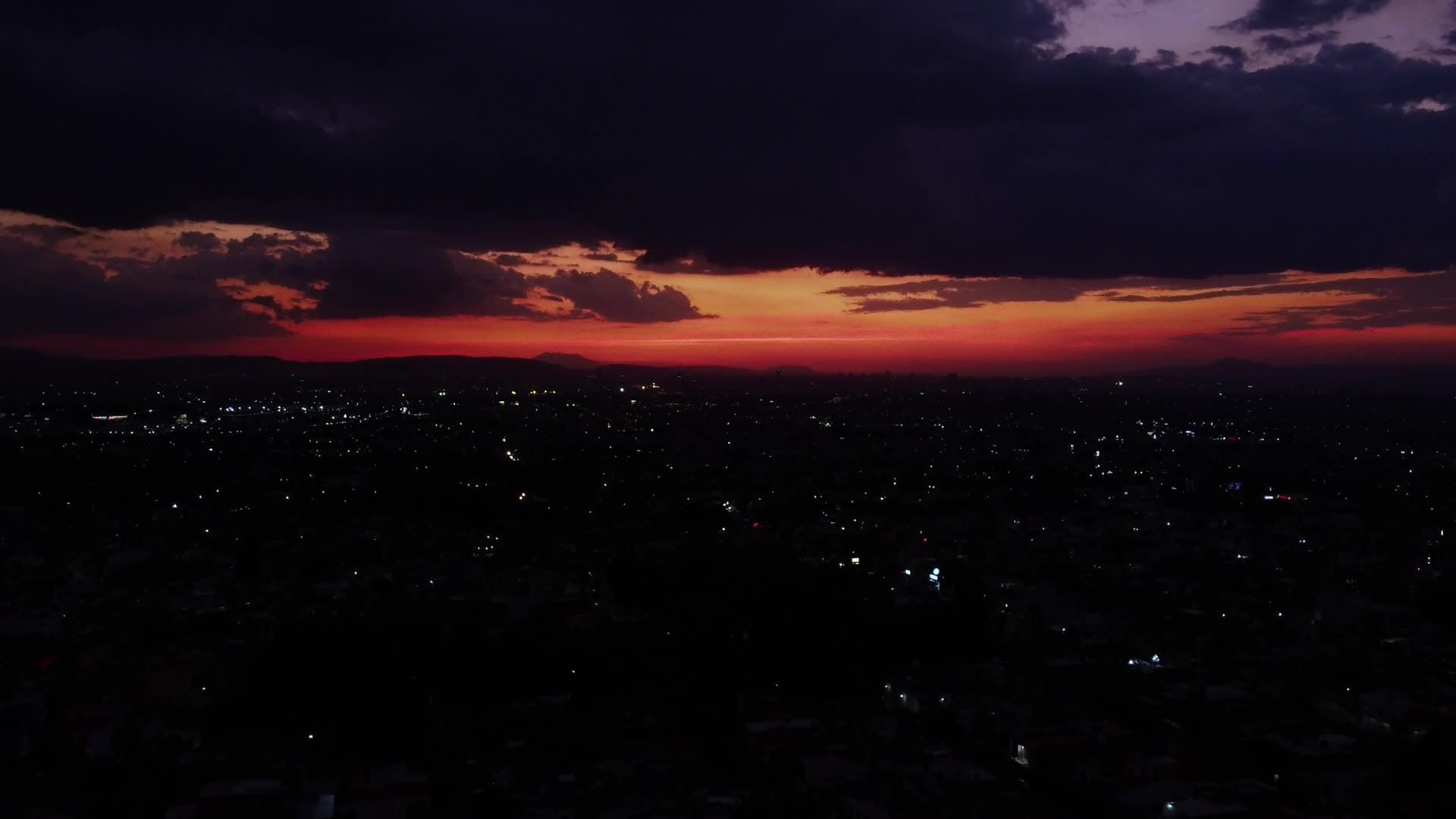 Dramatic red sunset over a city at dusk