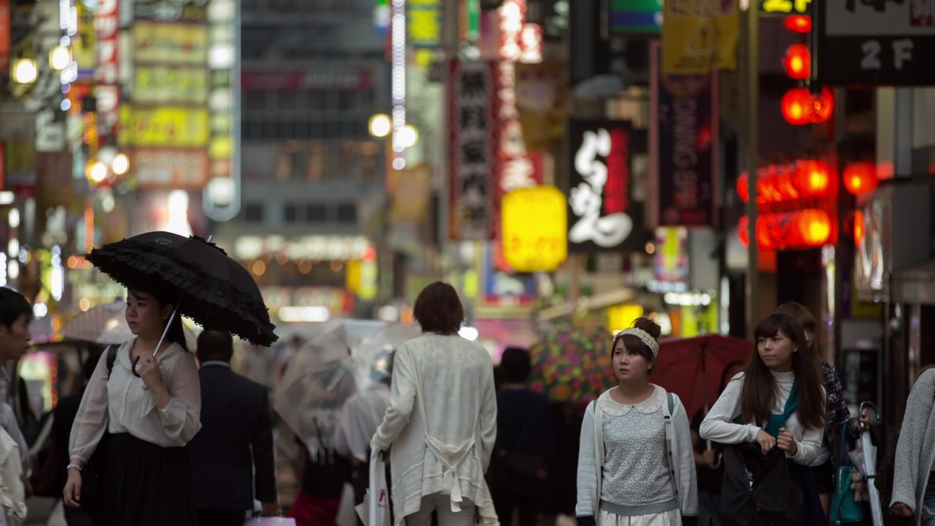 Crowded city street at night with illuminated signs