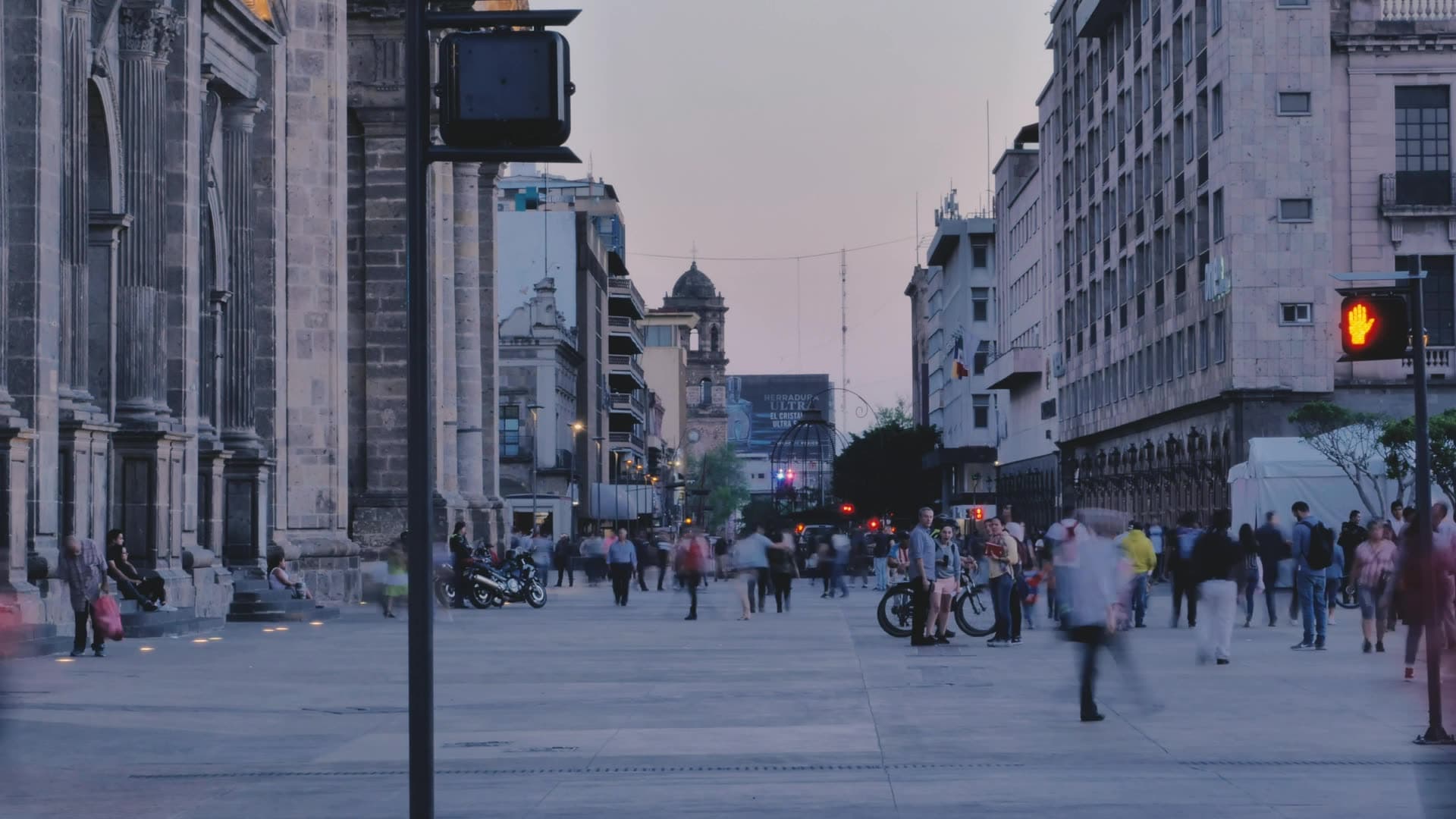 City street at dusk with pedestrians and historic buildings